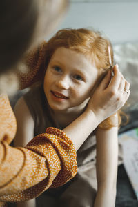 Young woman embracing daughter at home