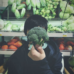 Man holding broccoli at market