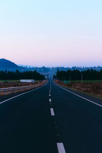 Road against clear sky at sunset