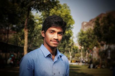 Portrait of smiling young man at public park