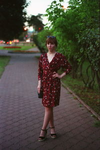 Full length of young woman standing against tree