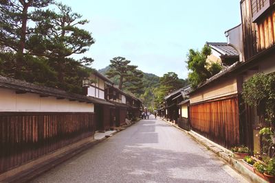 Empty road amidst buildings against clear sky