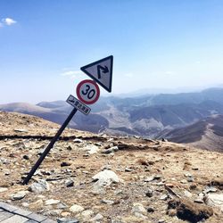 Information sign on road against sky