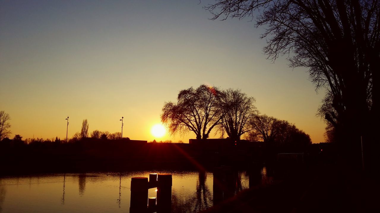 sunset, silhouette, sun, water, tranquility, tranquil scene, tree, scenics, beauty in nature, lake, clear sky, reflection, orange color, nature, river, idyllic, sky, sunlight, copy space, no people