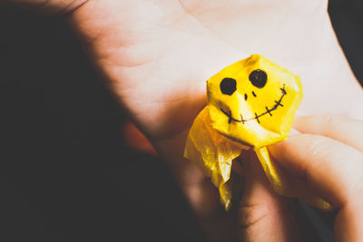 Close-up of hand holding yellow leaf