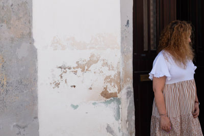 Rear view of woman standing against window