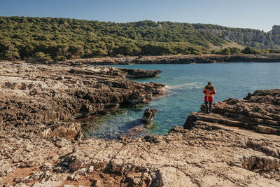 Man standing on shore against sky