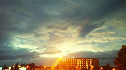 Low angle view of buildings against cloudy sky