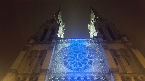 Low angle view of illuminated lighting equipment at night