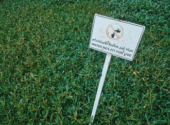 Close-up of information sign on grass