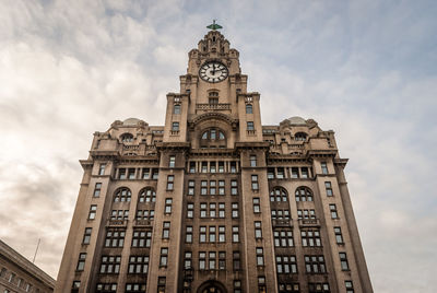 Low angle view of building against cloudy sky