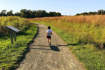 Rear view of girl walking on footpath