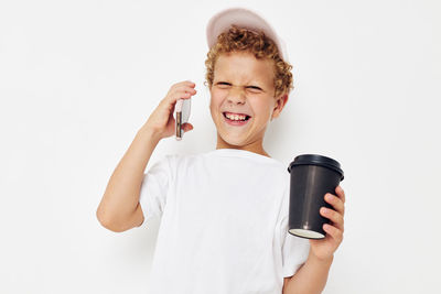 Smiling boy talking on phone against white background