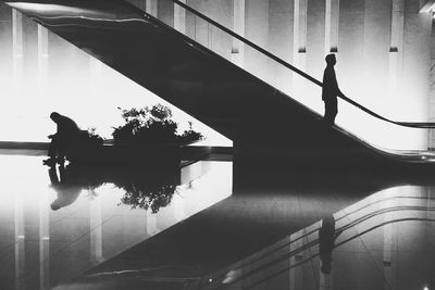 Silhouette people walking on railing