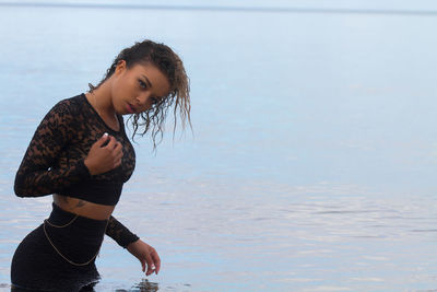 Side view of beautiful young woman in sea