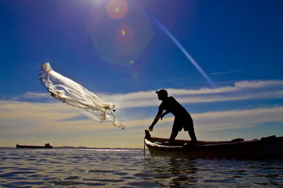 Silhouette of man in boat on sea