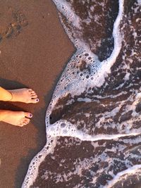 Low section of person standing on beach