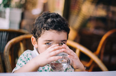 Close-up of boy sitting on table