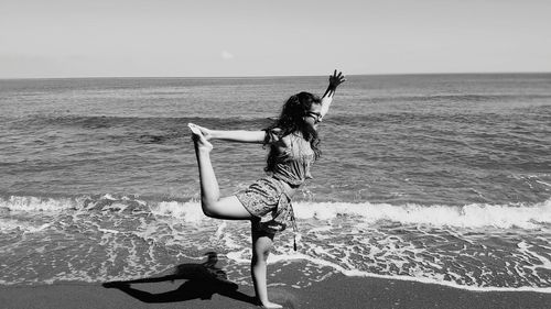Woman doing yoga pose on beach