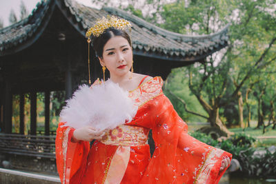 Young woman in traditional clothing standing at temple