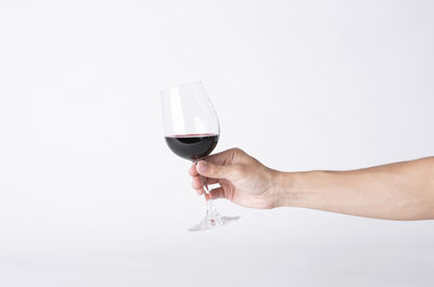 Midsection of man holding drink against white background