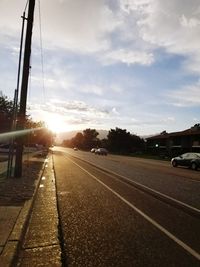 Cars on road against sky during sunset