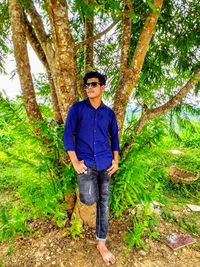 Portrait of young man standing in forest