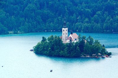 Scenic view of sea against trees and buildings