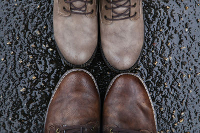 Close-up of shoes on wet road