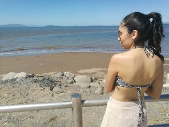 Rear view of young woman standing on beach