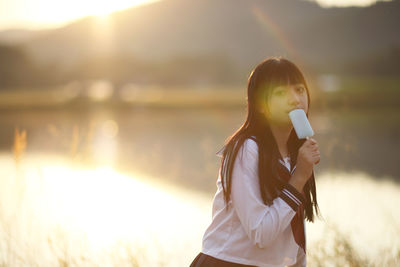 Portrait of young woman drinking water