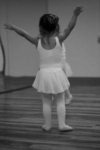 Ballerina girl dancing on floorboard at ballet studio