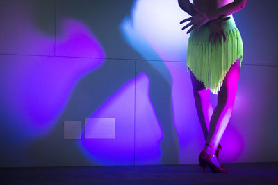 Low section of woman dancing in illuminated nightclub