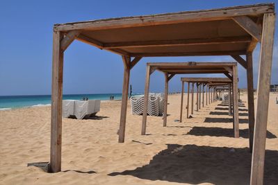 Chairs on beach against clear sky