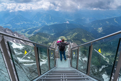 Rear view of man photographing on mountain