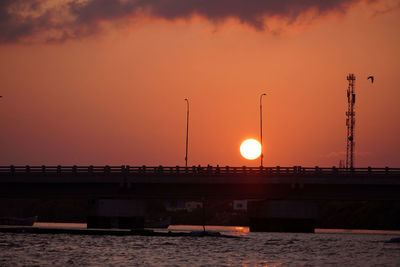 Bridge over river against romantic sky at sunset