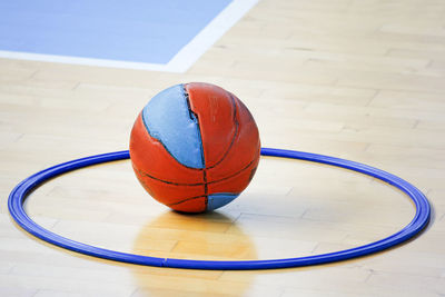 Basketball with plastic hoop on floor