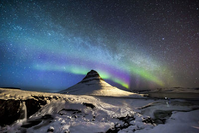 Scenic view of snowcapped mountains against sky at night