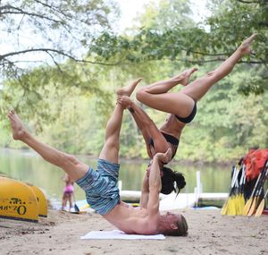 Fit man and woman exercising at lakeshore