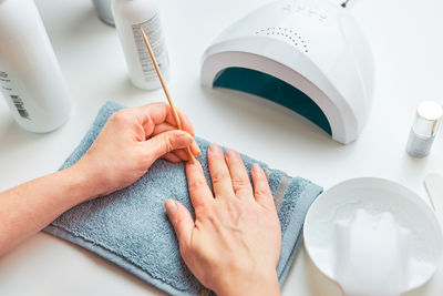 Woman preparing nails to apply gel hybrid polish using uv lamp. beauty wellness spa treatment