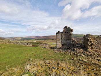 Old ruin on field against sky