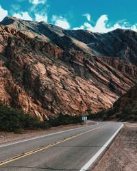 Road by mountain against sky