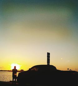 Silhouette of man standing at sunset