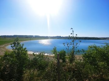 Scenic view of lake against sky on sunny day