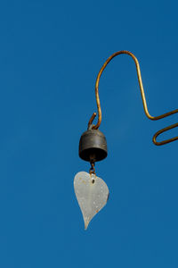 Close-up of hanging against blue sky