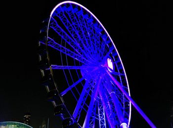 Low angle view of illuminated ferris wheel against sky at night