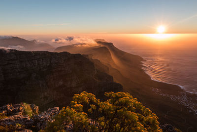 Scenic view of mountains and sea against sky during sunset