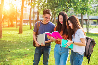 University students reading book at park