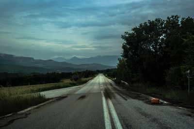 Road amidst trees against sky