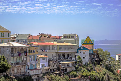 Houses in city against blue sky